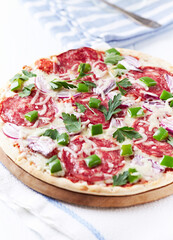 Pizza with salami and mozzarella cheese. Wooden background. Soft focus. Close up.	