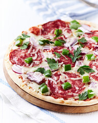 Pizza with salami and mozzarella cheese. Wooden background. Soft focus. Close up.	