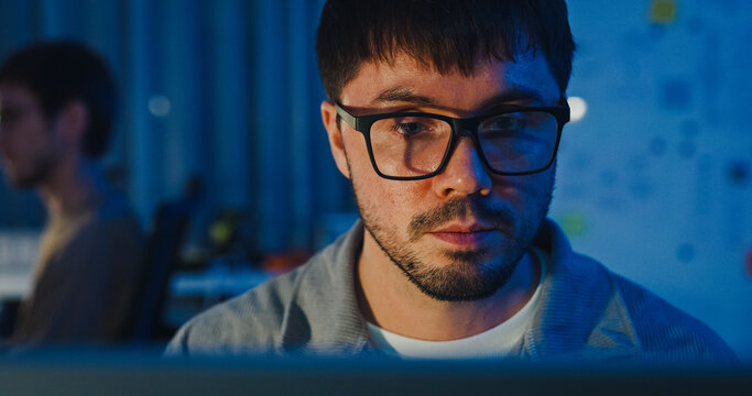 Closeup team adult male freelance work late typing write prompt AI bot app program nomad terminal code at office night. Artificial intelligence dashboard, robotics, user interface, machine learning.