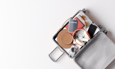 Open suitcase with packed travel essentials on a white background. 3d rendering