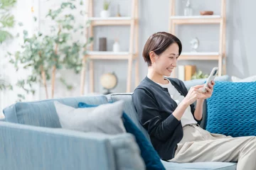 Zelfklevend Fotobehang スマホを見る女性 © naka
