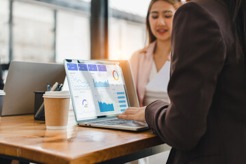 Data analysis dashboard on laptop screen with businesswoman discussing report in modern office, teamwork and collaboration for project success