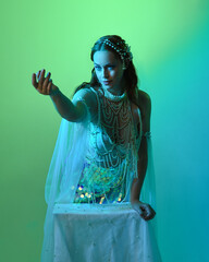 Fantasy studio portrait of a red-haired mermaid faery model wearing white pearl gown, fairytale...