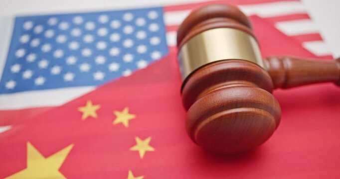 Judicial showdown in global trade, trade war and tariff war : A gavel placed over the US and Chinese flags symbolizes the complex legal and policy disputes at the heart of China-US trade negotiations.