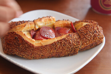 Freshly baked pastry with sesame and pepperoni in cafe