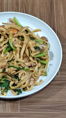 Fried noodles with vegetables and shrimp, looks very delicious served on a plate.