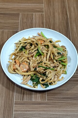 Fried noodles with vegetables and shrimp, looks very delicious served on a plate.