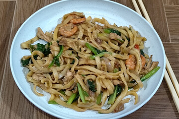 Fried noodles with vegetables and shrimp, looks very delicious served on a plate.