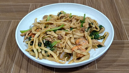 Fried noodles with vegetables and shrimp, looks very delicious served on a plate.