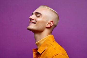 Purple solid background. Visual idea art of style for aging men. A joyful male captured in a professional portrait. Modish men's buzz cut haircut - midlife white man with blond hair.