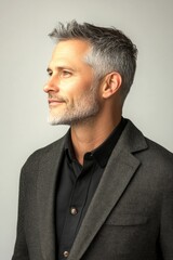 Obraz premium Pure white solid background. Idea of style for aging men. Modish men's crew cut haircut - midlife white man with grey hair. A serene and handsome man posing in style.
