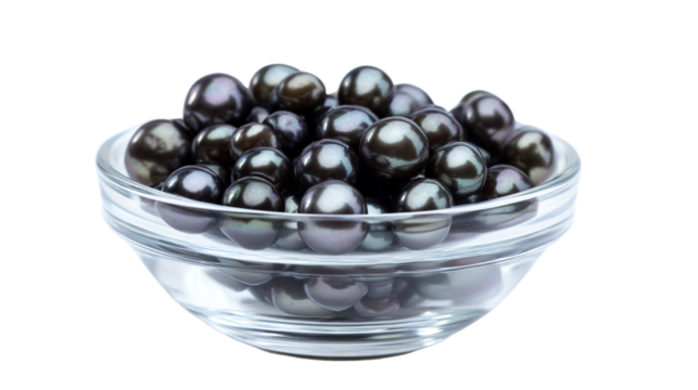 a glass bowl filled with black pearls on a white surface