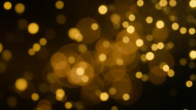 Blurred yellow abstract background of bokeh and small round particles of energy magical holiday flying dots on a black background