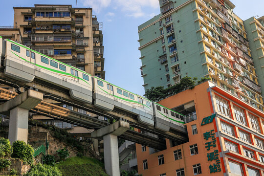 Chongqing, China - October 20. 2023: Monorail Metro Passing Through a high-rise residential building at the Station Liziba in Chongqing.