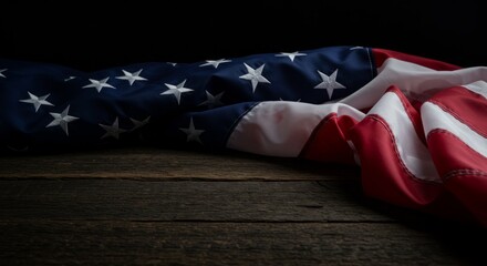 Worn American flag displayed on rustic wooden planks against dark background