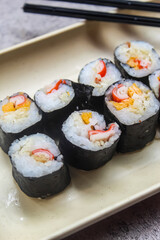 some pieces of sushi on a plate with chopsticks