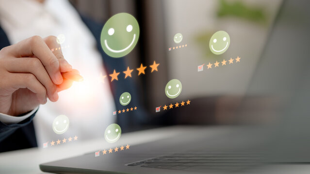 Businessman hand pointing to five star rating and smiley face icon on virtual screen. Concept of customer satisfaction, online review, feedback, CRM and quality service.
