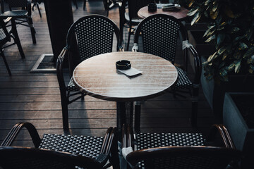 An empty table and chairs in the garden of the restaurant during the day