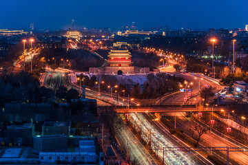 Yongdingmen City Tower at night in Beijing, China, with vehicle flow, traffic, and urban nightlife