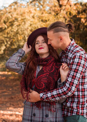 Fototapeta premium young couple in love walking, kissing and having fun in the autumn park