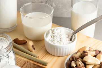 Brazil nut milk, and powder are beautifully arranged on a wooden surface, showcasing their textures and colors in a cozy kitchen atmosphere, illuminated by soft natural light