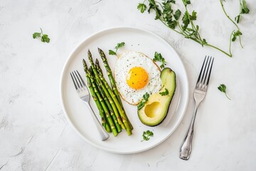 Healthy breakfast plate featuring grilled asparagus, fried egg, and avocado