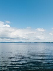 Obraz premium The view from across the water of far off land and hills.