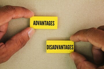 hand holding colored stick with the words Advantages and Disadvantages. the concept of advantage or disadvantage of something