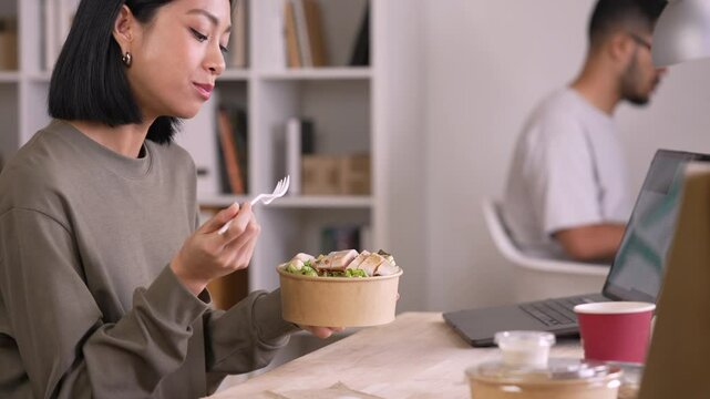 Woman eating healthy meal while working, Businesswoman having a lunch break at the office