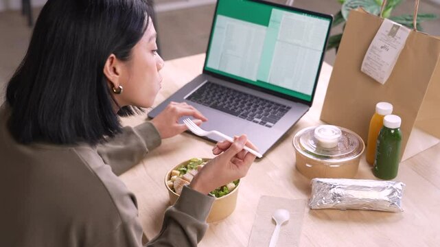 Woman eating healthy meal while working, Businesswoman having a lunch break at the office