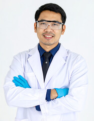 Confident Asian chemist stands with arms crossed, wearing safety goggles and lab coat, exuding professionalism in clean studio setting with white background
