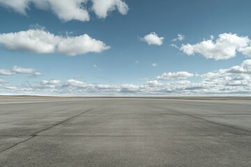 Empty paved expanse under a partly cloudy sky