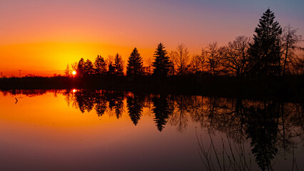 Obraz premium Summer sunset or sundowner view with reflections in a pond near Aholming, Deggendorf, Bavaria, Germany