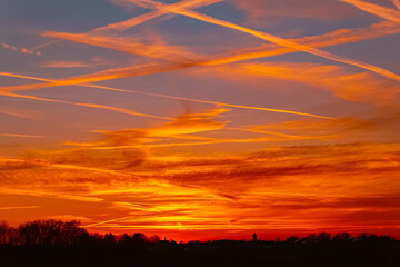 Spring sunset or sundowner with dramatic clouds and a church silhouette seen from near Arbing,...
