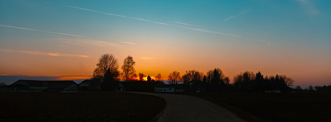 Spring sunset or sundowner with a church silhouette seen from near Arbing, Osterhofen, Deggendorf,...