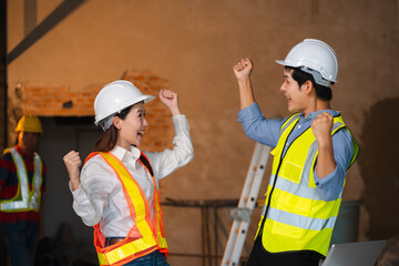 Successful engineer teams working together wear worker helmets hardhat on construction site.
