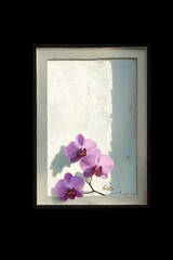 Three delicate pink orchid flowers with deep purple centers placed on a textured background with white and muted blue tones in a rectangular frame