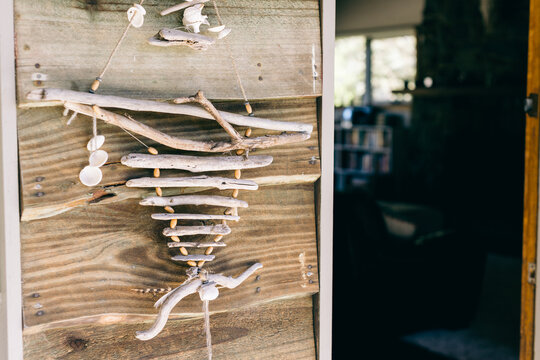 home made coastal ornament hanging by front door of a beach house