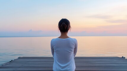 Asian female stretching on a wooden pier at dawn with calm ocean backdrop