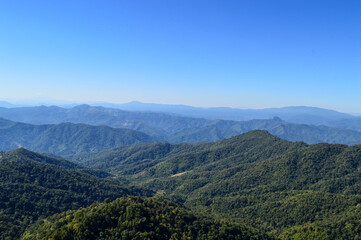 Naklejka premium Distant Mountains and Forest with Trees and Sky in Northern Thailand.