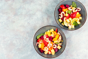 Fresh shrimp salad with colorful fruits.