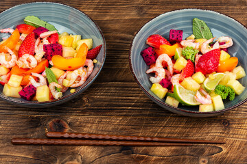 Tasty seafood salad and exotic fruits.