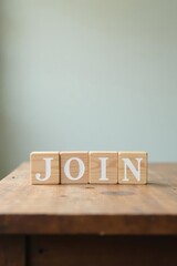 Wooden blocks spelling JOIN on a rustic table against a muted background, signifying membership, community, or teamwork