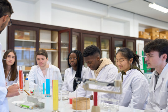 Chemistry teacher explaining lesson to multiethnic students institute