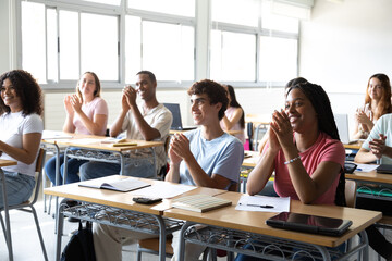 Happy students clapping in university or high school classroom