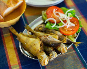 Tasty fried scad served with tomatoes, onion and letucce, Galician cuisine