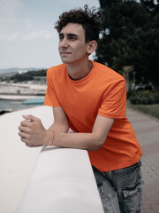 A young attractive student is walking on the embankment.