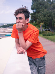 A young attractive student is walking on the embankment.