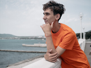 A young attractive student is walking on the embankment.
