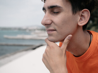 A young attractive student is walking on the embankment.